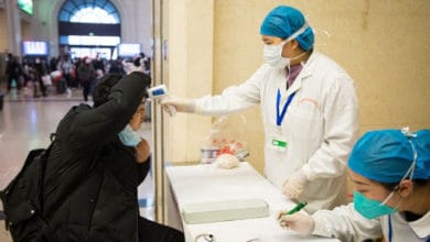 ممرضة صينية تفحص احدى الأشخاص بعد تفشي فيروس كورونا