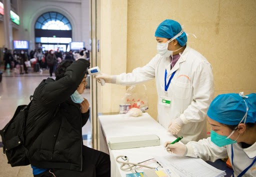 ممرضة صينية تفحص احدى الأشخاص بعد تفشي فيروس كورونا