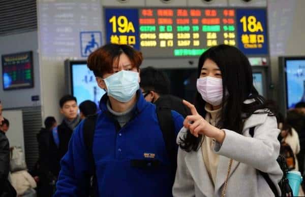 مواطنان صينيان في إحدى محطات القطار يرتديان الكمامات الواقية اثر انتشار فيروس كورونا الجديد