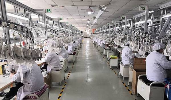 عمال ينتجون كمامات طبية يمكن إعادة استخدامها في إحدى مصانع شركة شانغهاي جو تشين